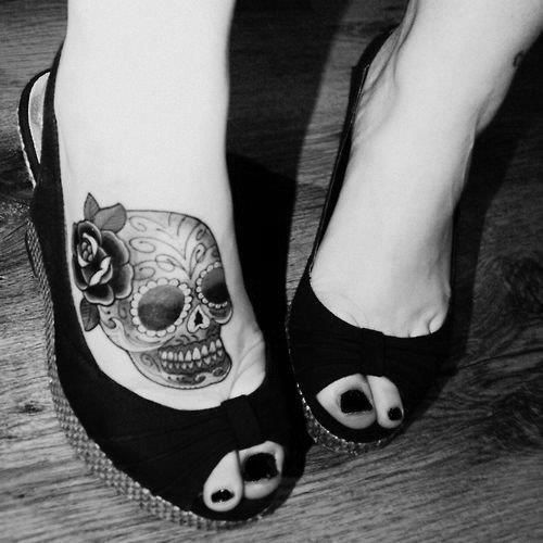 Un tatouage d'une crane sur le pied